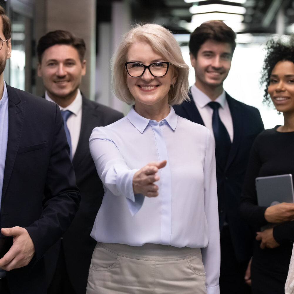 Staff,Members,Team,Gather,In,Office,Hallway,Look,At,Camera